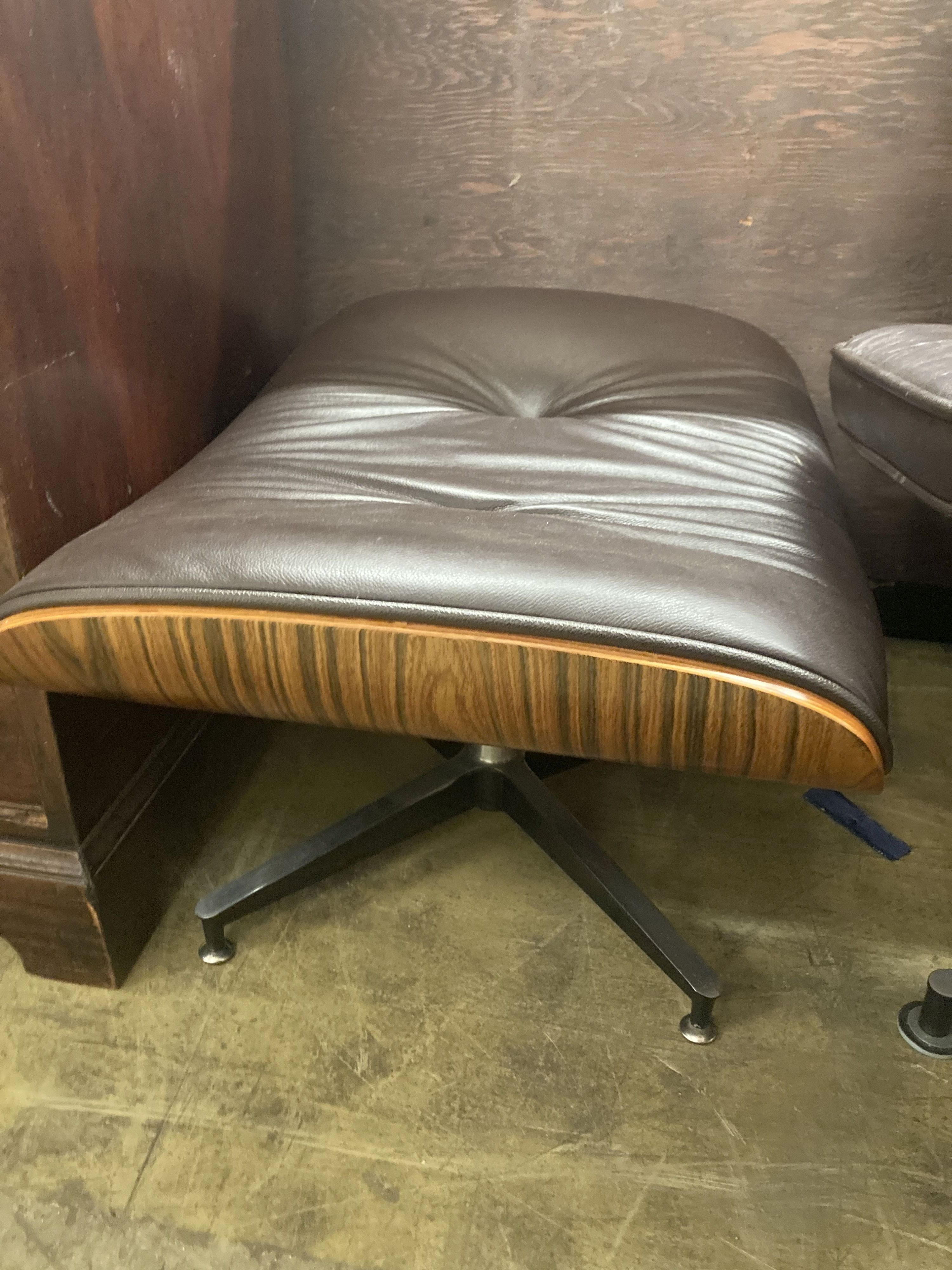 An Eames style modern buttoned dark brown leather swivel chair, width 92cm, depth 74cm, height 78cm and matching stool